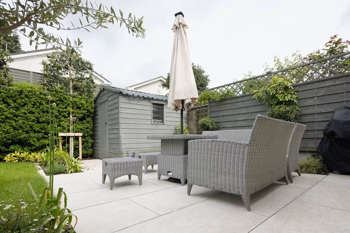 Gefliester Terrassenbereich mit Sitzgelegenheit im Garten